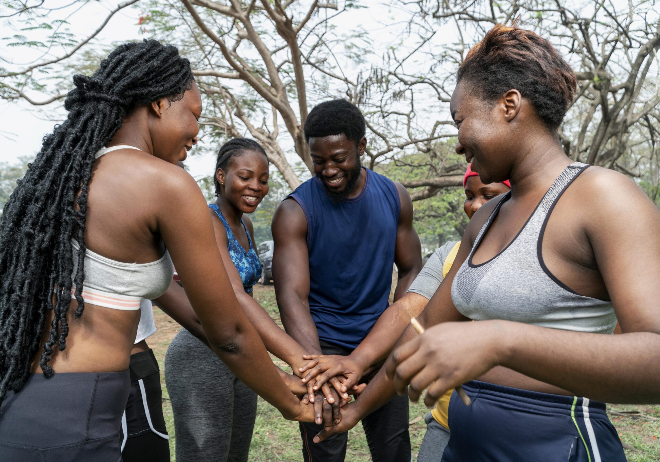 A farmer smiling while holding a crate of fresh tomatoes.